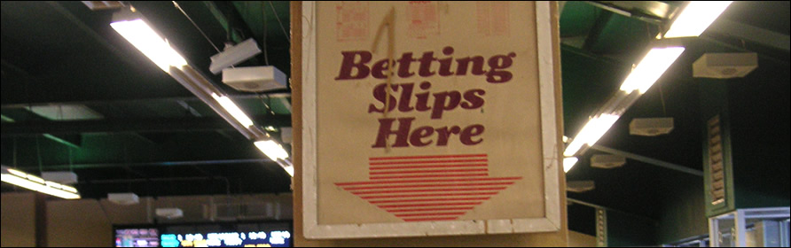 Sign at a track that reads "Betting Slips Here"
